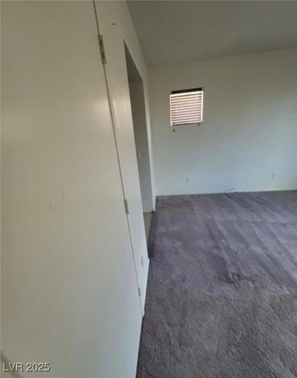 unfurnished room with dark colored carpet