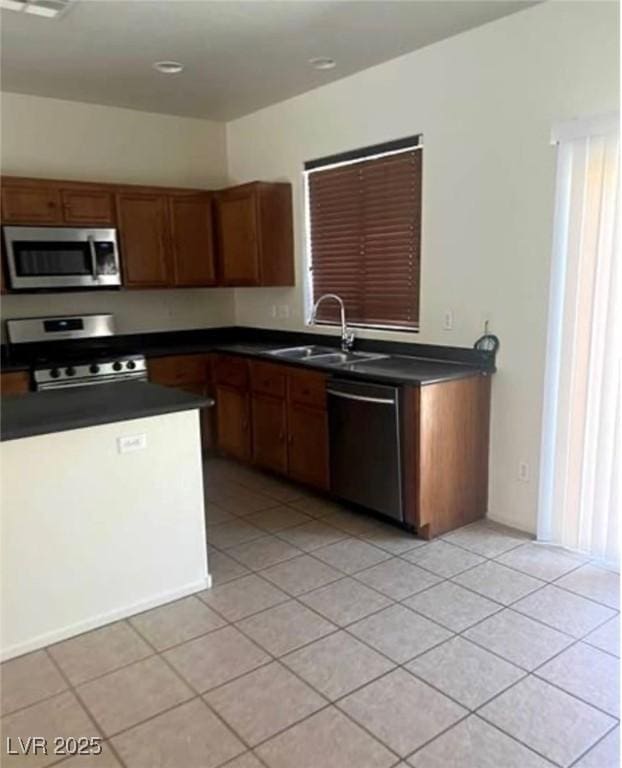 kitchen with light tile patterned floors, stainless steel appliances, and sink