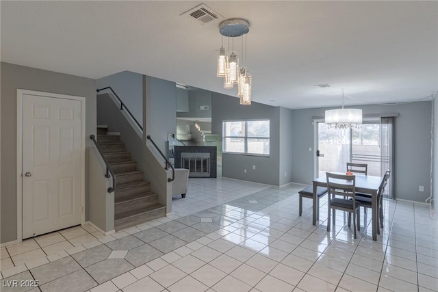 6250 W Flamingo Rd Unit 7, Las Vegas, NV 89103 - unfurnished dining area with a notable chandelier, light tile patterned flooring, and a tiled fireplace