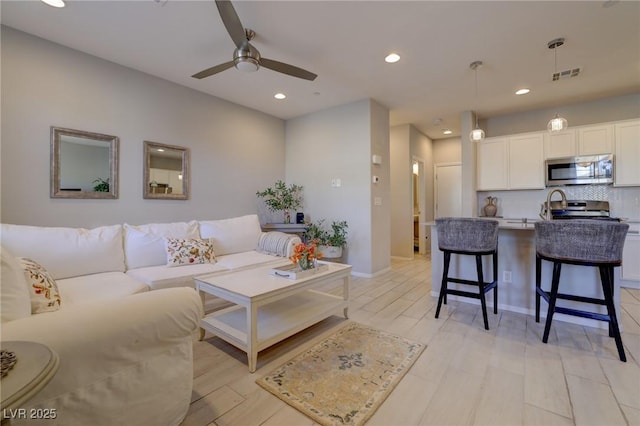 living room featuring recessed lighting, visible vents, ceiling fan, and light wood finished floors