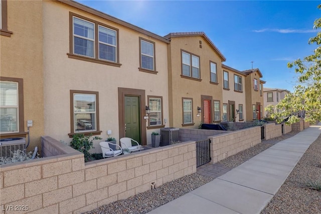 view of front of property featuring a fenced front yard, cooling unit, and stucco siding