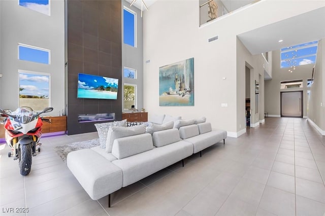 living room with light tile patterned floors and a towering ceiling