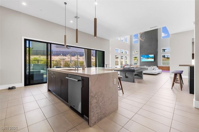 kitchen with modern cabinets, a sink, an island with sink, and light tile patterned floors