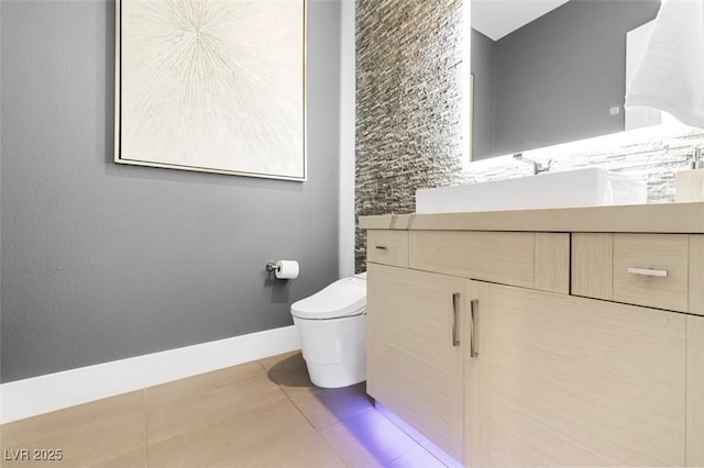 bathroom with toilet, baseboards, vanity, and tile patterned floors