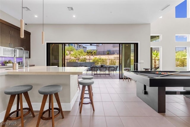 kitchen with light countertops, a breakfast bar area, and visible vents