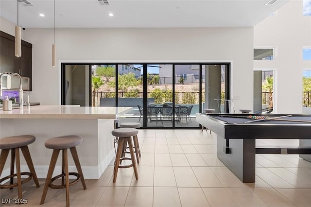 interior space featuring light tile patterned floors, a sink, visible vents, and recessed lighting