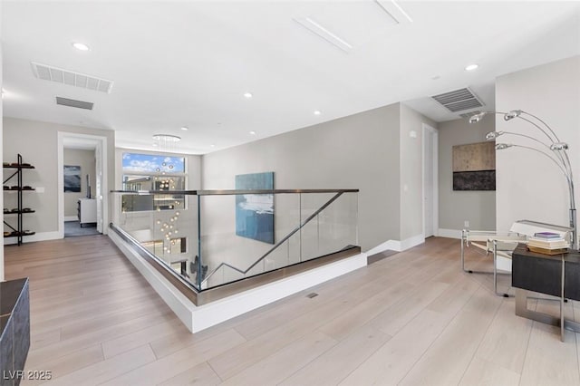 corridor featuring recessed lighting, wood finished floors, an upstairs landing, baseboards, and visible vents