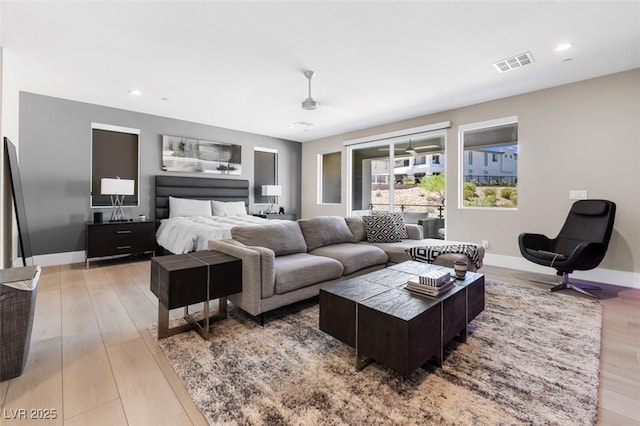 living area with light wood-style flooring, recessed lighting, visible vents, and baseboards