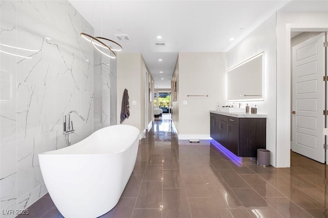 interior space featuring dark tile patterned floors, visible vents, tile walls, and recessed lighting