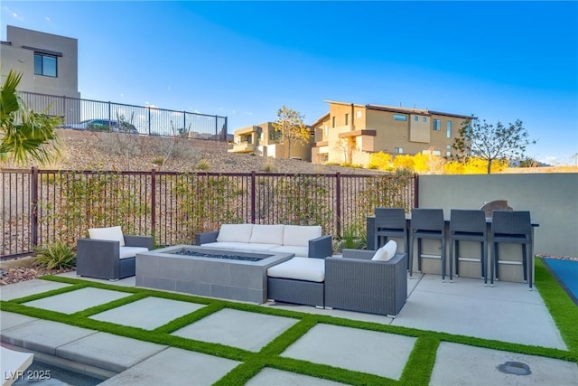 view of patio / terrace with a fenced backyard and an outdoor living space with a fire pit