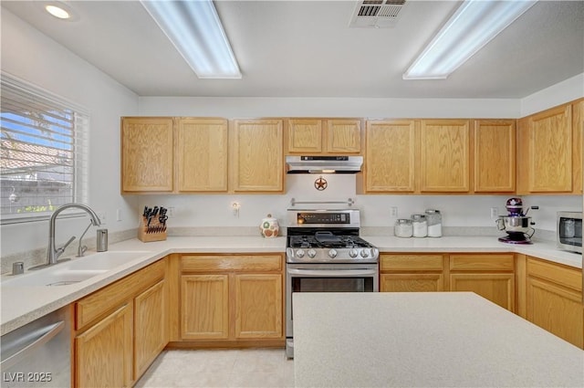 kitchen featuring stainless steel appliances, light brown cabinets, and sink