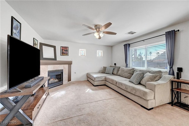 living room with carpet floors, a tile fireplace, and ceiling fan