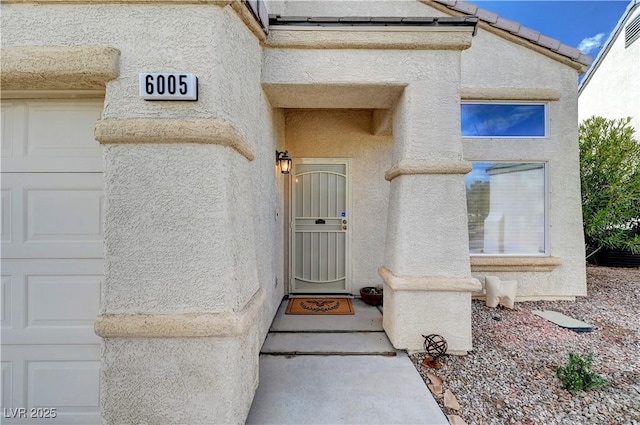 view of exterior entry with a garage