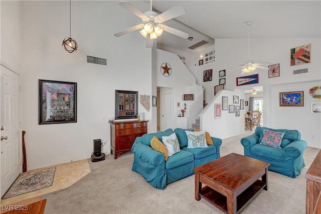 carpeted living room featuring ceiling fan and high vaulted ceiling