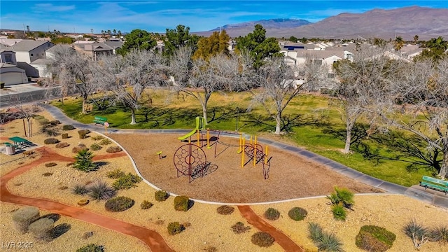 surrounding community with a playground and a mountain view