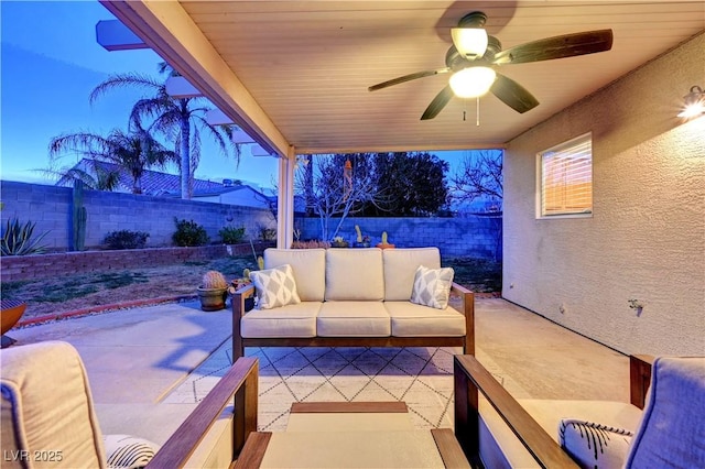 patio terrace at dusk featuring outdoor lounge area and ceiling fan