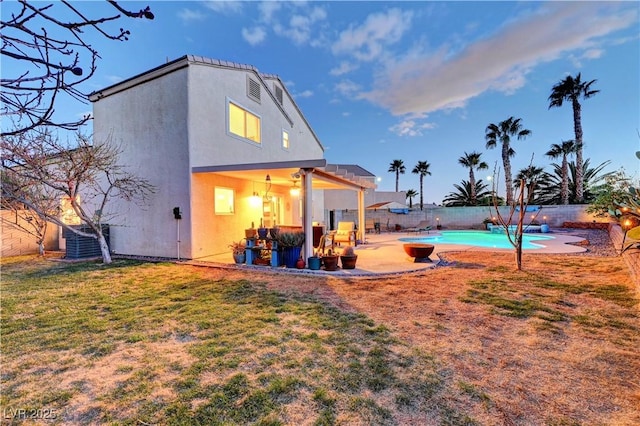 back of house with a lawn, a patio area, cooling unit, a fenced in pool, and ceiling fan