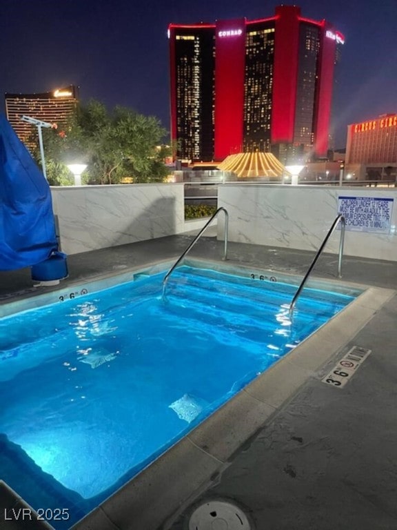 view of pool at twilight