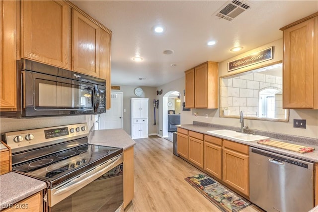 kitchen featuring sink, appliances with stainless steel finishes, and light hardwood / wood-style floors