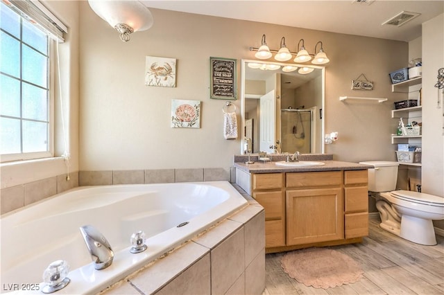 full bathroom featuring shower with separate bathtub, toilet, wood-type flooring, and vanity