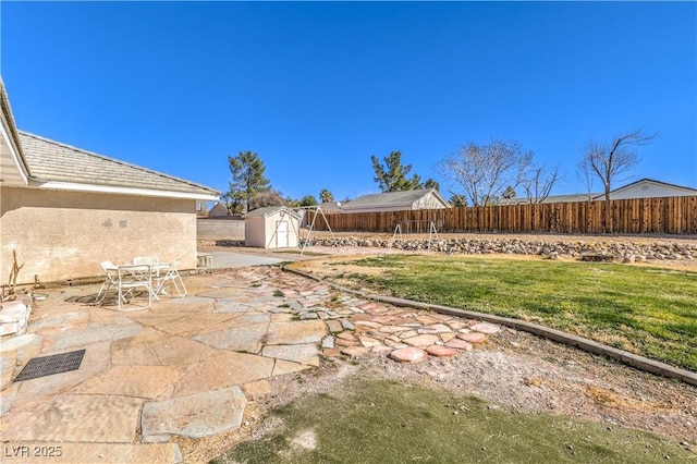 view of yard featuring a shed and a patio