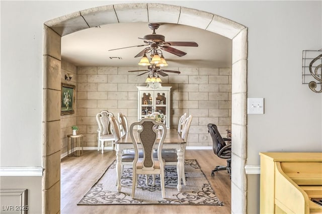 dining space with light hardwood / wood-style floors and ceiling fan