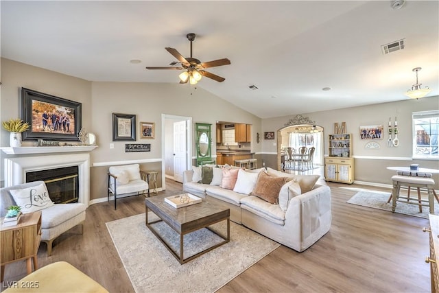 living room featuring ceiling fan, hardwood / wood-style flooring, and lofted ceiling