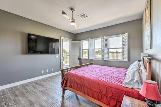 bedroom featuring hardwood / wood-style floors, multiple windows, ceiling fan, and access to outside