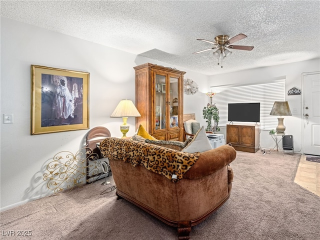 living room featuring carpet floors, a textured ceiling, and ceiling fan