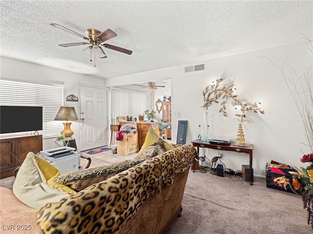 living room with carpet, ceiling fan, and a textured ceiling