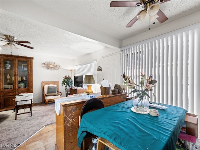 carpeted dining room with beam ceiling, ceiling fan, and a textured ceiling