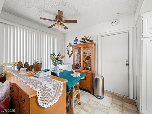 dining area featuring ceiling fan and a textured ceiling