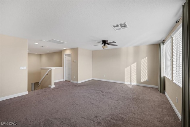 spare room with carpet floors, recessed lighting, visible vents, and baseboards