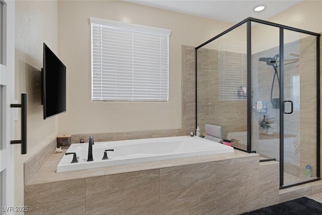 bathroom featuring a stall shower and a bath