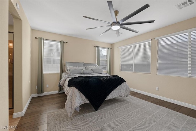 bedroom with a ceiling fan, wood-type flooring, visible vents, and baseboards