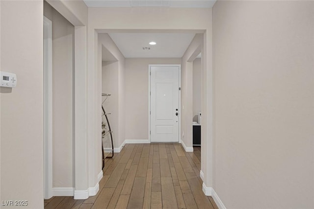 hallway with wood finished floors and baseboards