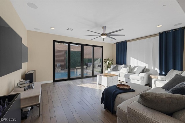 living room featuring dark wood-style floors, visible vents, a ceiling fan, and recessed lighting