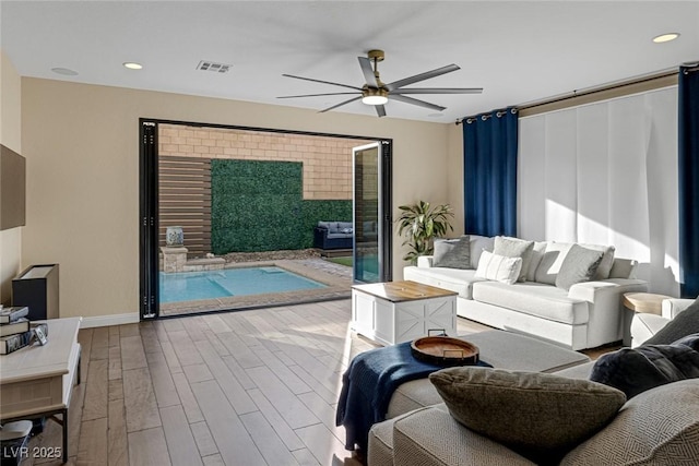 living room featuring recessed lighting, wood finished floors, visible vents, and a ceiling fan