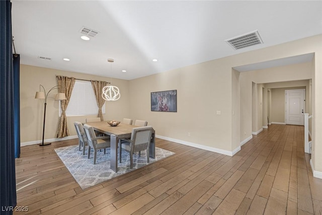 dining space featuring visible vents, baseboards, and wood finished floors