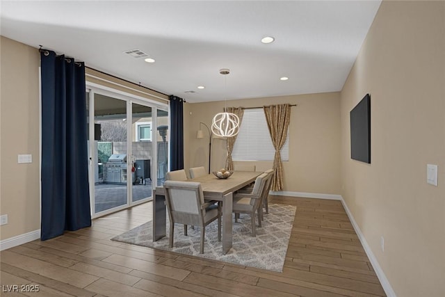 dining area featuring baseboards, visible vents, wood finished floors, and recessed lighting