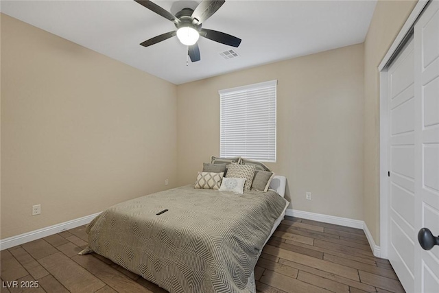 bedroom featuring wood-type flooring, visible vents, ceiling fan, and baseboards