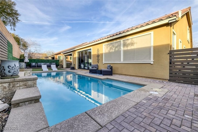 view of swimming pool with a fenced in pool, fence, an outdoor living space, and a patio