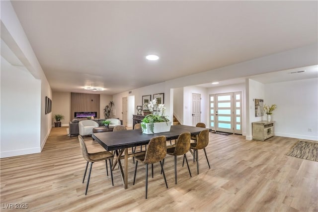 dining area with french doors and light hardwood / wood-style floors