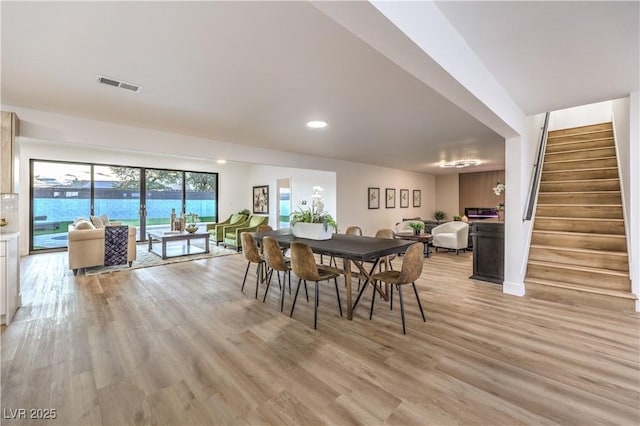 dining area featuring a water view and light hardwood / wood-style floors