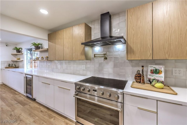 kitchen featuring light hardwood / wood-style flooring, beverage cooler, electric range, wall chimney exhaust hood, and decorative backsplash