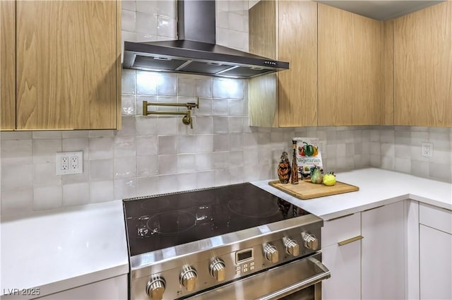 kitchen featuring electric stove, backsplash, and wall chimney range hood