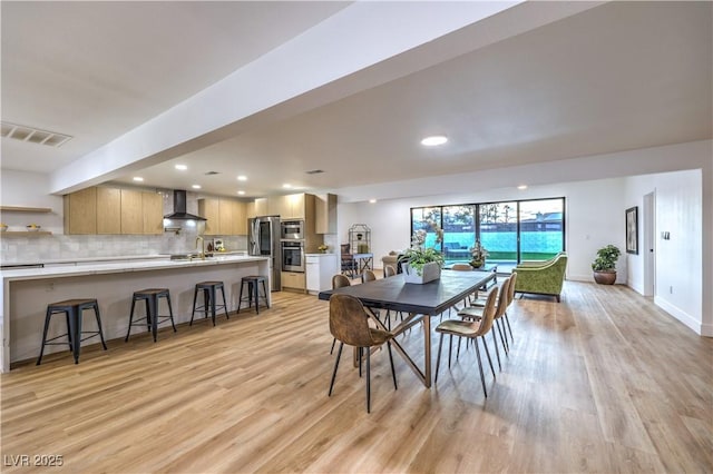 dining space featuring sink and light hardwood / wood-style flooring