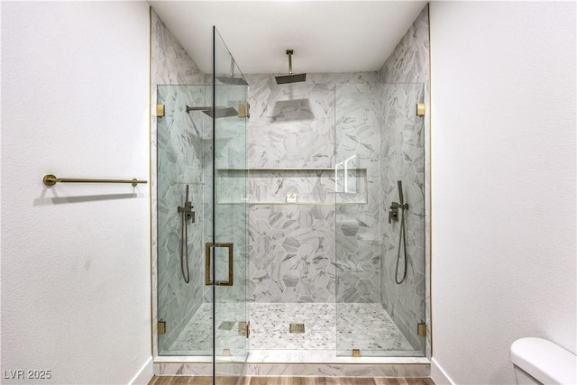 bathroom with wood-type flooring, an enclosed shower, and toilet