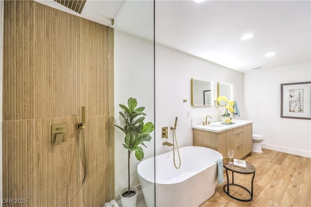 full bathroom featuring hardwood / wood-style flooring, vanity, toilet, and separate shower and tub