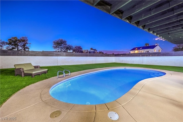 pool at dusk with a yard and a patio area